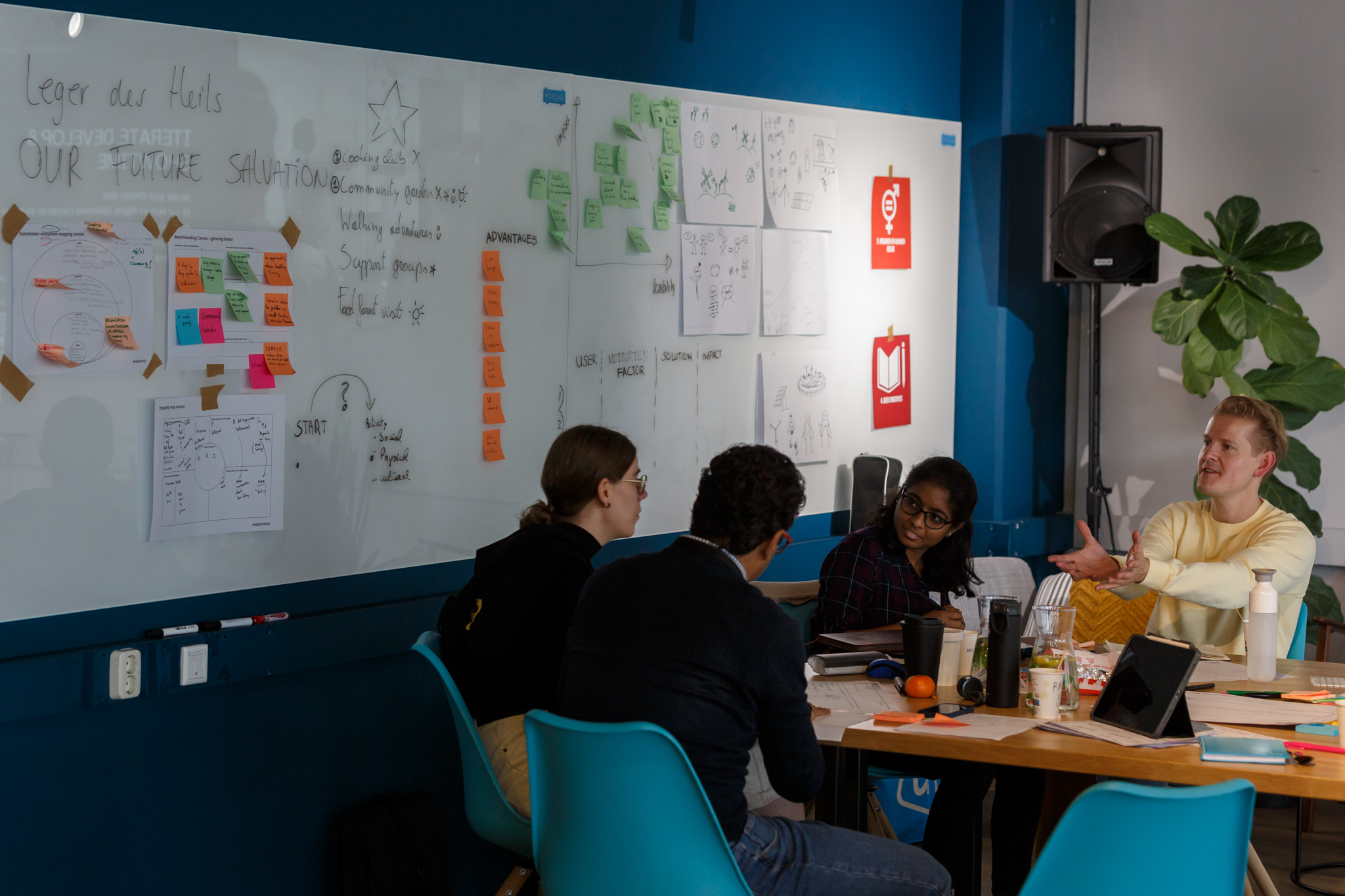 people discussing in front of a whiteboard